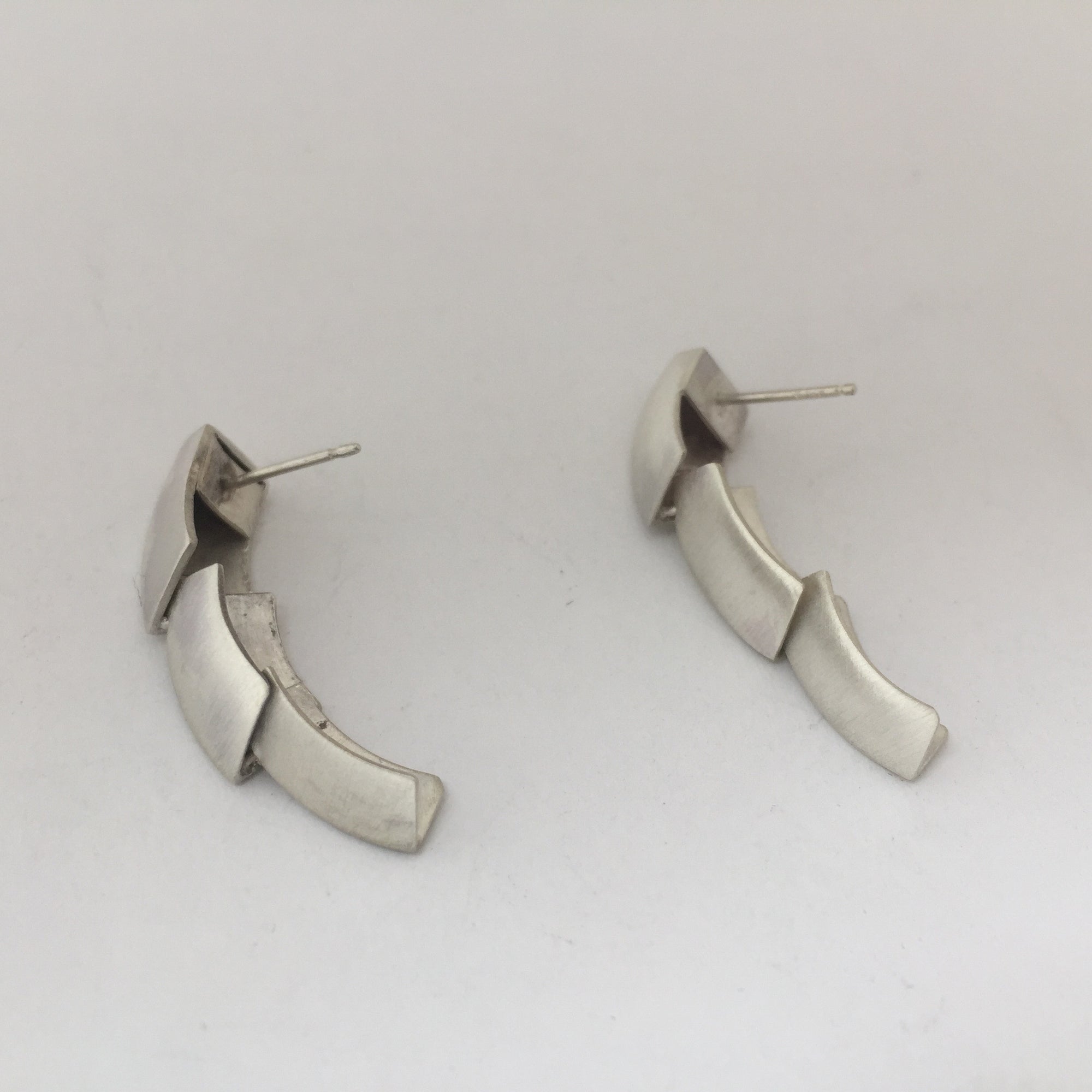 Silver dangle earrings made of 3 scale like pieces.