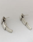 Silver dangle earrings made of 3 scale like pieces.