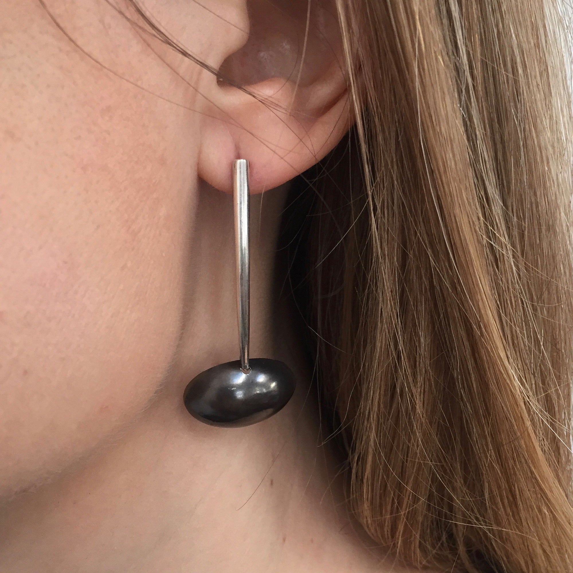 Drop earrings with black oval at the bottom.