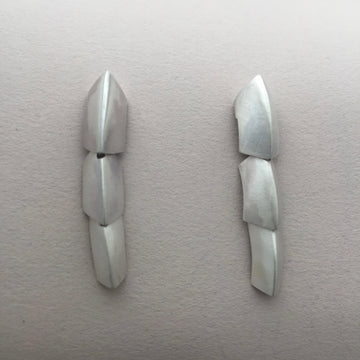 Silver dangle earrings made of 3 scale like pieces.